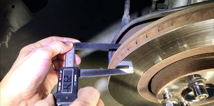 Measuring warped brake disk rotor minimum thickness using digital micrometer for machine grinding turning rotors 